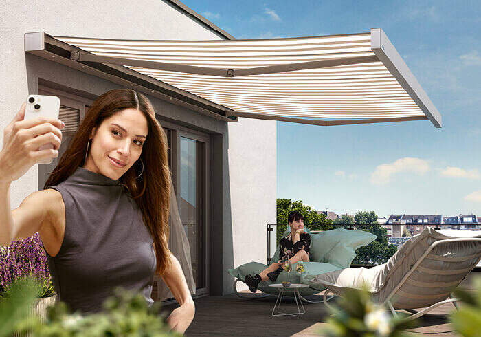 Frau macht Selfie auf Terrasse mit Markise, Lounge und Sonnenschutz außen